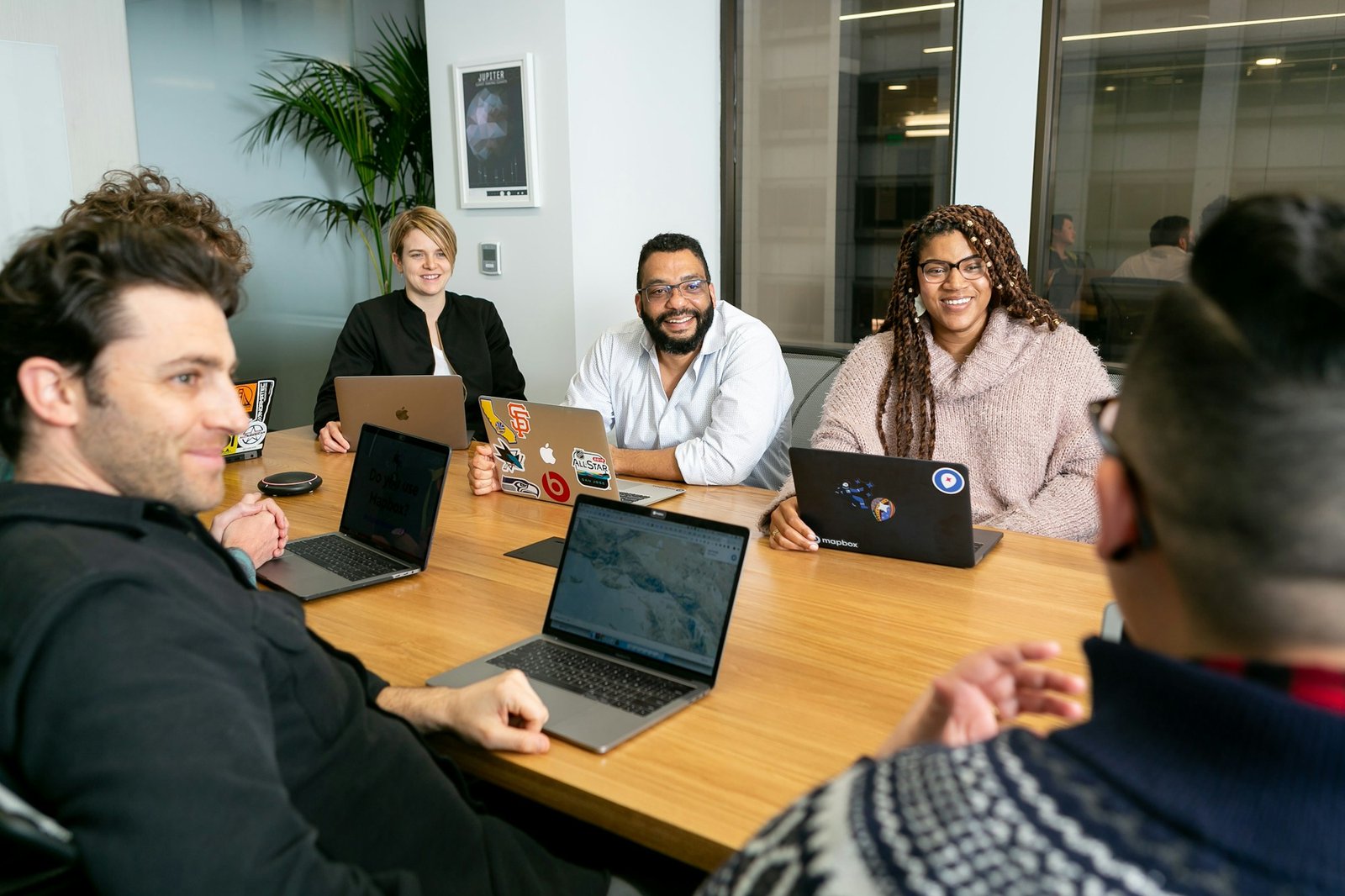 Business team collaborating around a shared table with laptops