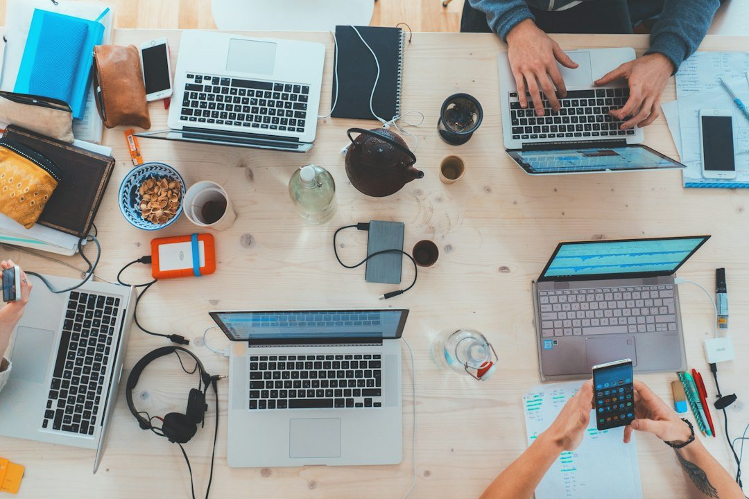 A collaborative team working around a table with laptops